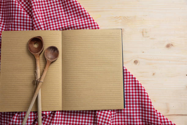 istock Notebook, kitchen utensils and red tablecloth on wooden table, top view, copy space 1033034682