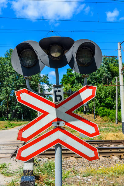 railroad crossing sign and semaphore in front of the railroad crossing - railroad crossing railway signal gate nobody imagens e fotografias de stock