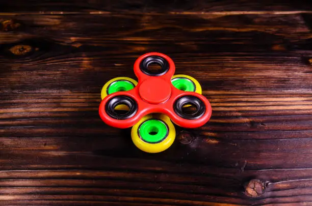 Photo of Two fidget spinners on wooden desk