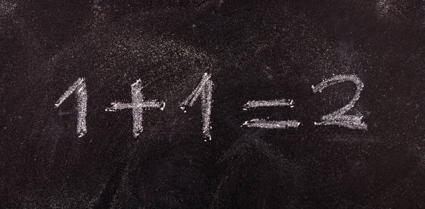 istock simple equation 1+1=2 isolated, on blackboard background. 1033037254