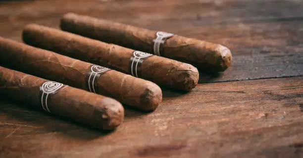 Cuban cigars on wooden background, copy space