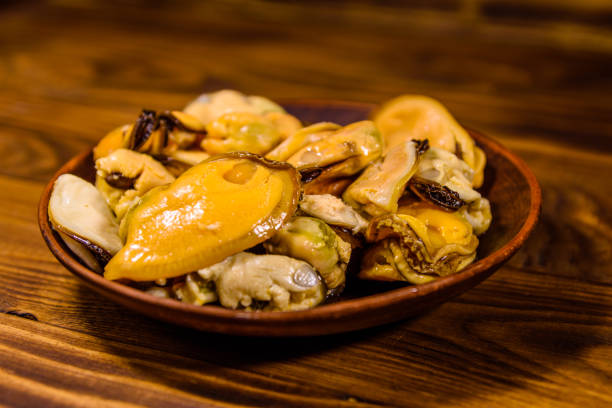 istock Ceramic plate with prepared mussels on wooden table 1033037446
