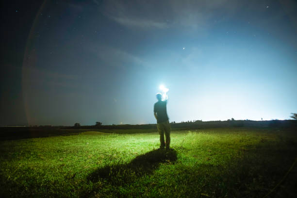 istock one man standing in the grass field under sky at night 1033045354