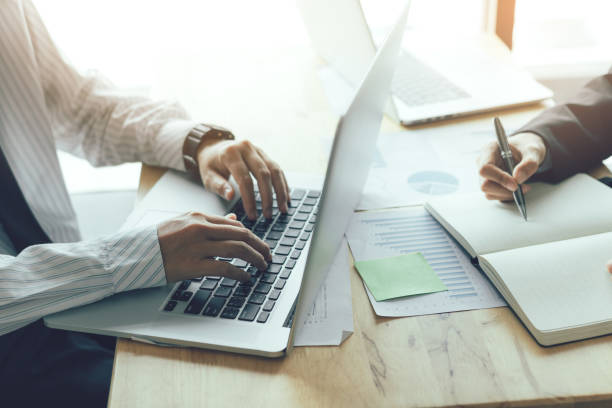 istock Business people using laptop and writing make note in office room. 1033045442