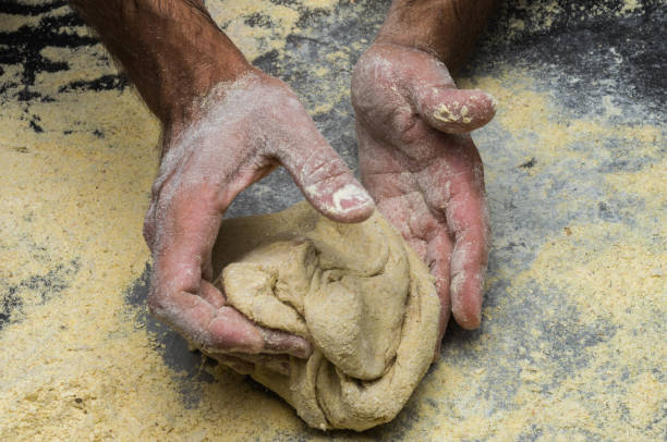 istock Male hands kneading dough on sprinkled 1033048522
