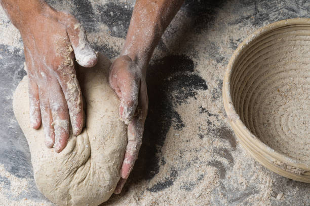 istock Male hands kneading dough on sprinkled 1033053842