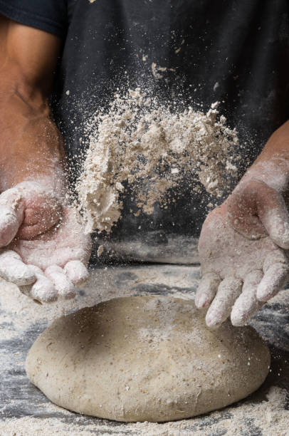 istock Male hands kneading dough on sprinkled 1033053908