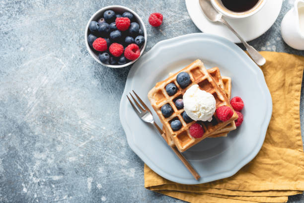 Belgian waffles with ice cream and berries Belgian waffles with ice cream and berries on concrete background. Top view of sweet tasty breakfast. Copy space for your text vanilla ice cream photos stock pictures, royalty-free photos & images