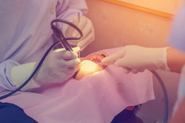 istock dentist cleaning the teeth patient with ultrasonic tool 1033062548