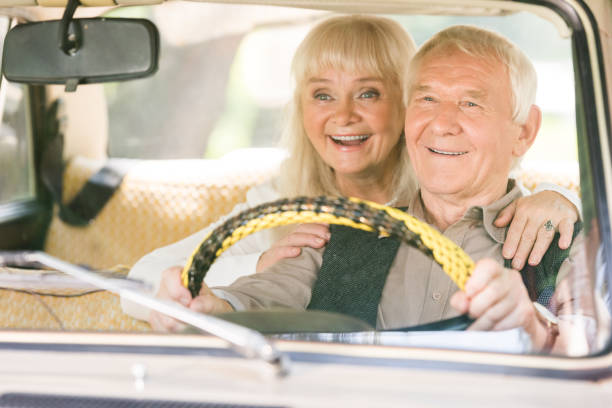 istock smiling senior woman hugging man while he driving retro car 1033072820