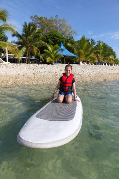 istock Vanuatu Girl enjoying paddle boarding ona tropical beach 1033080992
