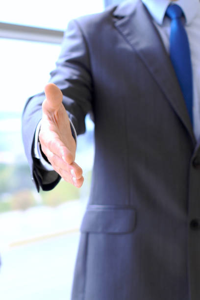 istock Unknown business man offering handshake while standing straight. Success cooperation and agreement concepts. 1033085136