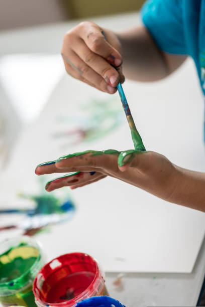 istock Closeup view of a child having fun with colourful hand paints 1033090680
