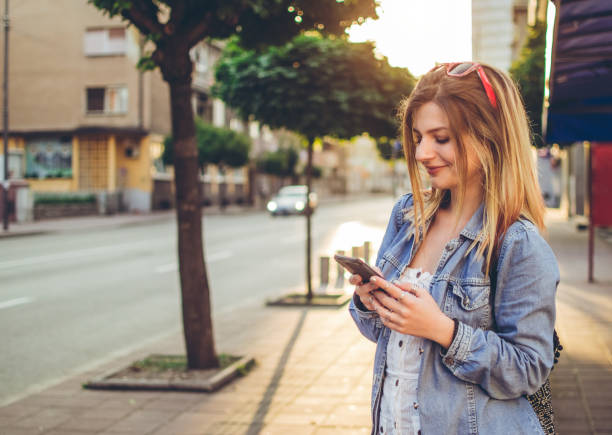 istock Young girl typing message on the street 1033093842