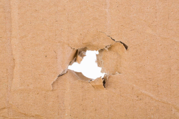 istock Ripped hole in brown cardboard on white background 1033109494