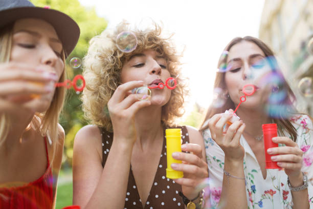istock Young women blowing soap bubbles outdoors 1033114842