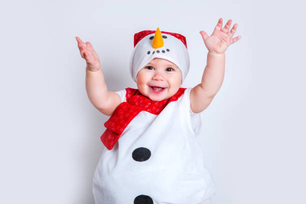 Amazed attractive baby girl in Christmas costume having fun . Close-up portrait little girl in snowman costume stock photo