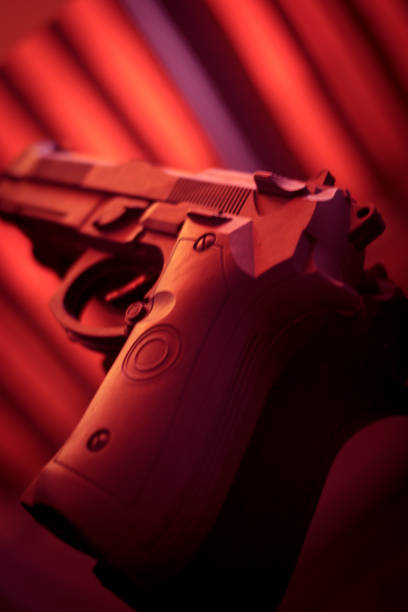 istock Pistol automatic handgun weapon in silhouette in hand of killer atmospheric dark dramatic photo. 1033149806