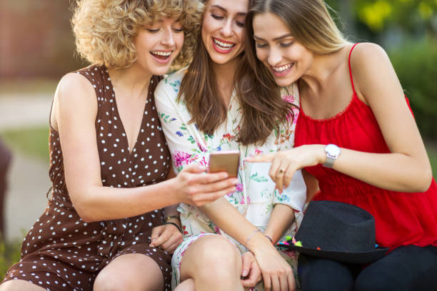 istock Three happy young women having fun with smart phone 1033154398