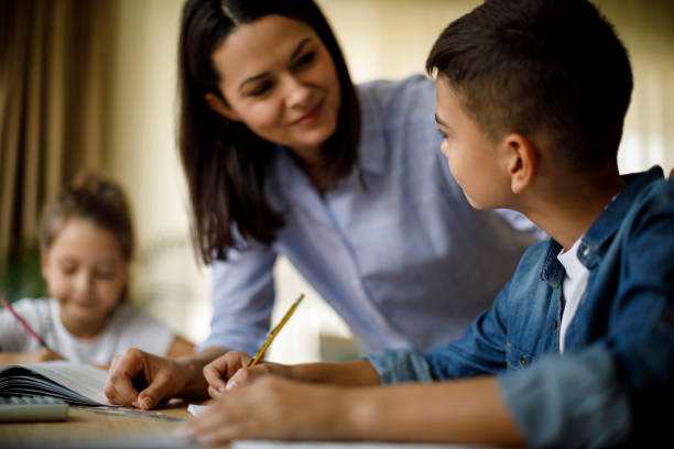 istock Mother helping her kids with homework 1033164464
