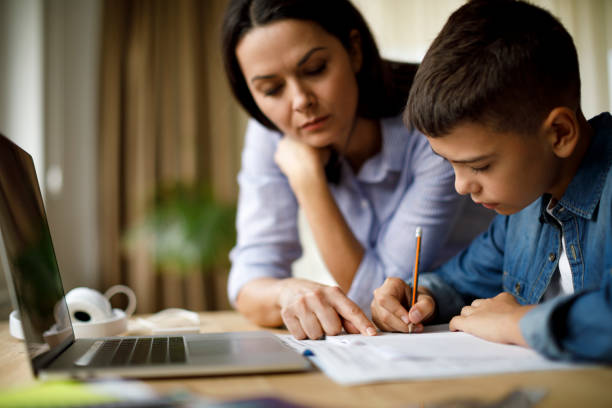 istock Mother helping teenager with homework 1033164874