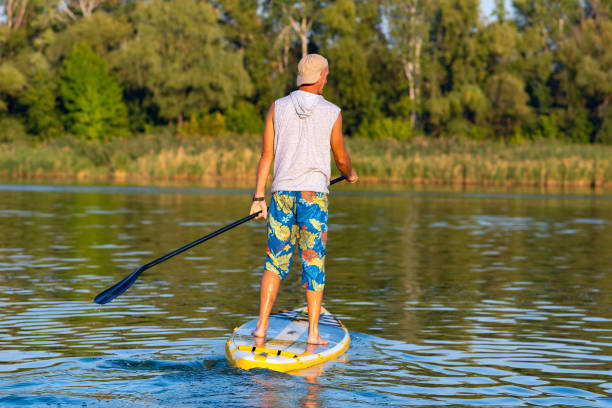 istock Happy man paddling on a SUP board 1033167390