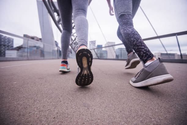 istock Unknown athlete couple jogging on dock at sunset, close up. 1033170916