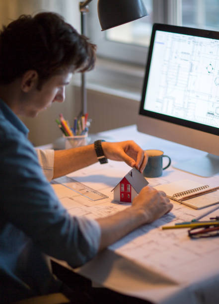 istock Architect working with blueprints in the home office. 1033177538