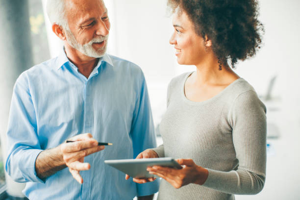 istock Senior man presenting data to young woman on digital tablet 1033180154