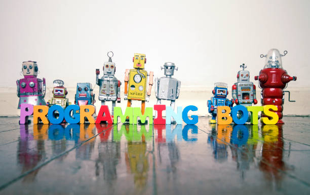 istock PROGRAMMING BOTS wooden letters and retro robot toys 1033180734