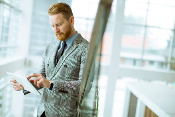 istock Confident businessman using tablet on office stairs 1033184450
