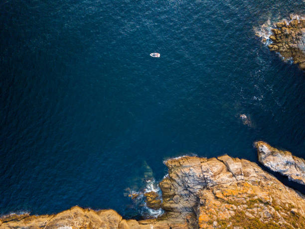 Aerial view of a small boat in the Galician coast, at the opening of the Ria de Pontevedra, were the Atlantic ocean meets the land.