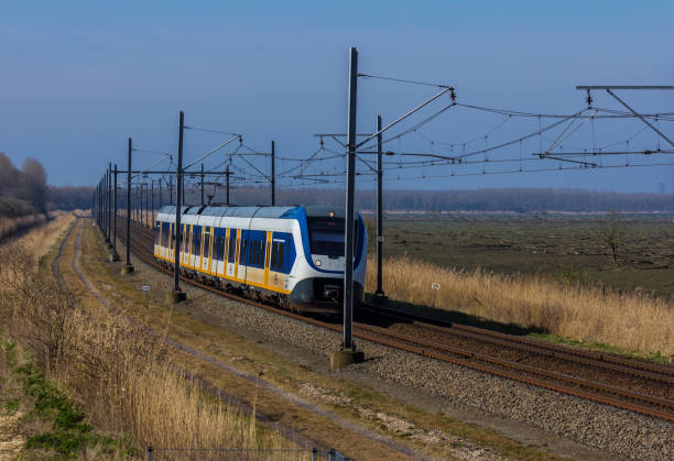 Flevoland, the Netherlands - March 26, 2016: Dutch snel train traveling through countryside.