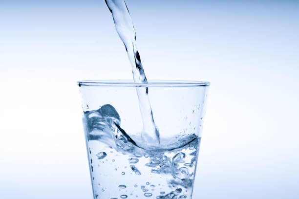 istock Close up pouring drinking water into glass, studio shot 1033223656