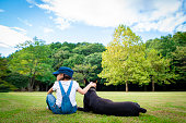 芝生の上に座っている少女とドーベルマン