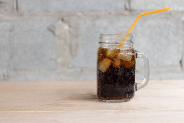 istock cola with ice in glass on wood table 1033226766