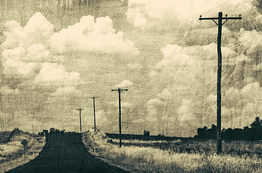 Vintage grunge retro style black and white road through rural landscape.