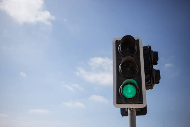 istock Green traffic light.  Blue sky with few clouds background. Close up under view, copyspace. 1033275228