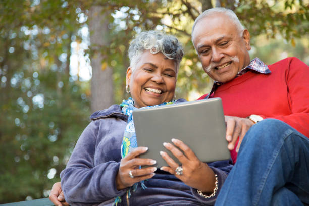 istock Active senior adult couple using digital tablet outdoors. 1033277580