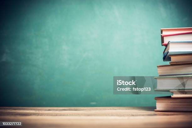 Textbooks On Wooden School Desk With Chalkboard Stock Photo - Download Image Now - Education, Chalkboard - Visual Aid, School Building