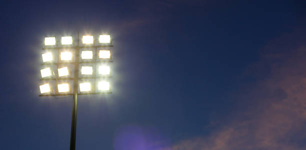 stadion lichter turm am himmelshintergrund - floodlight blue sky day stock-fotos und bilder