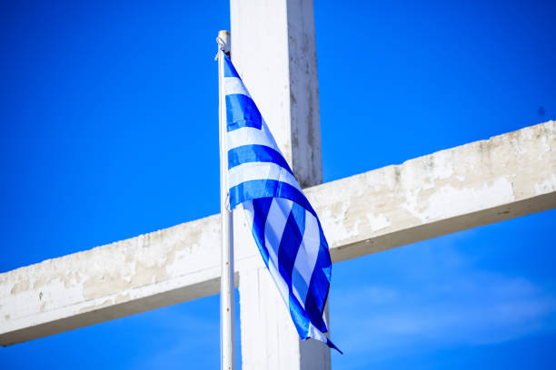 Greek flag waving on a white cross and blue sky background