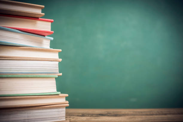 istock Textbooks on wooden school desk with chalkboard. 1033277806