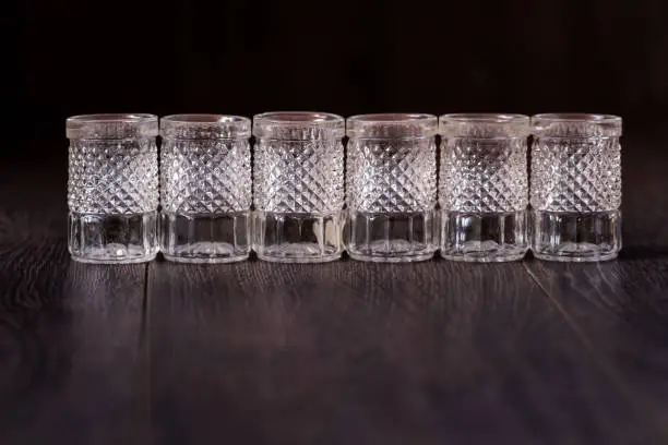 Decorative cut glass crystal glasses on brown background