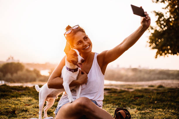 istock Young woman with dog creates a selfie 1033284042