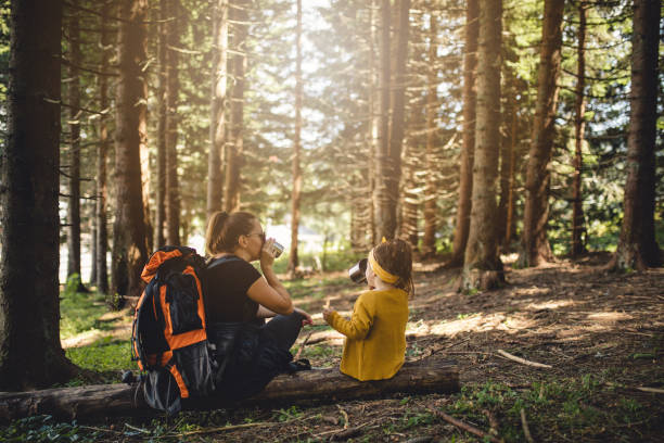 istock Mother and daughter refreshing in forest while hiking 1033295770