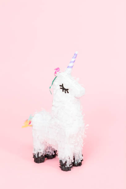 istock White unicorn pinata on a pink background. 1033298470