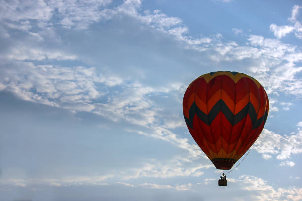 istock Hot air balloon floating in cloudy sky 1033307184