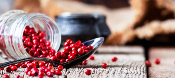 istock Pink pepper rose in a glass jar and spoon 1033307778
