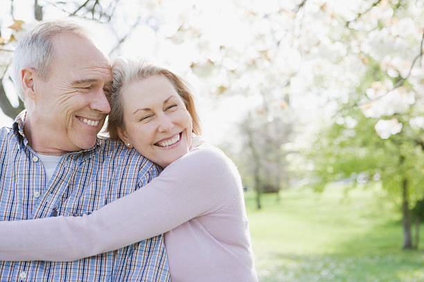 Smiling senior couple hugging in park  carefree senior stock pictures, royalty-free photos & images